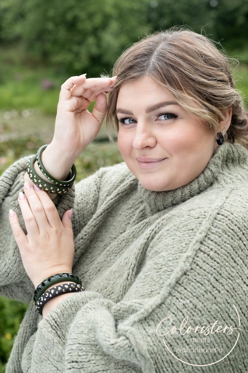 Plus size Frau mit Armreifen und Ohrringen mit Kristallen in khaki und schwarz. Plus size women with earrings and bangles with crystals in khaki and black.