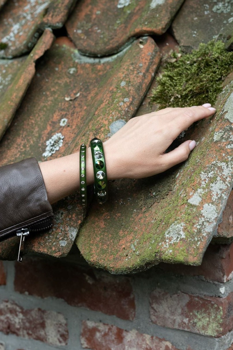Hand mit Armreifen mit Kristallen in khaki. Hand with bangles with crystals in khaki.