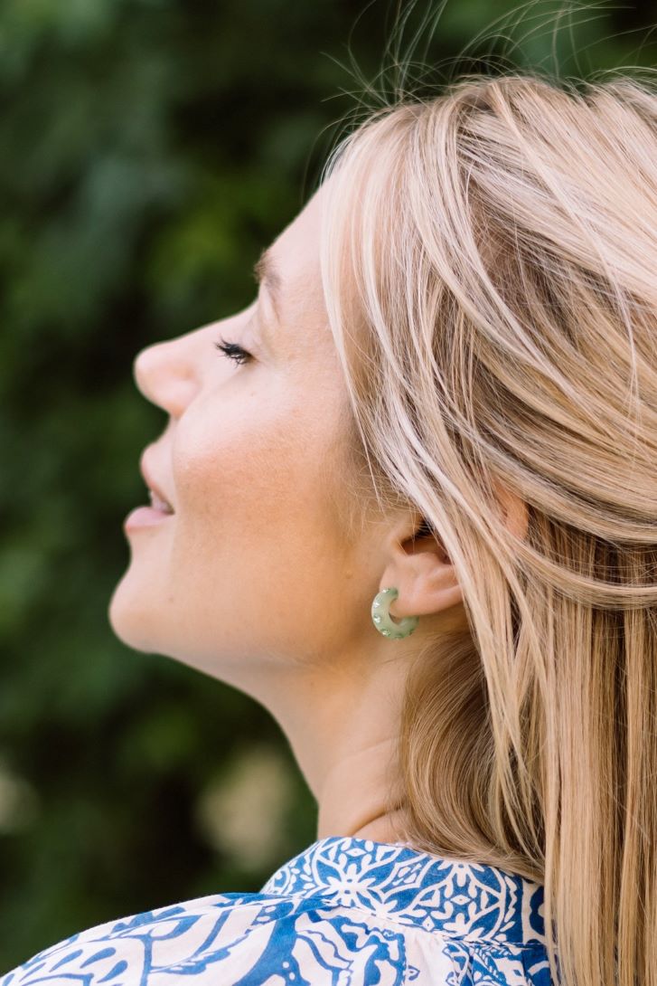 Frau mir Coloristers Ohrringen mit Kristallen in Hellgruen. women with Coloristers Earrings with crystals in light green