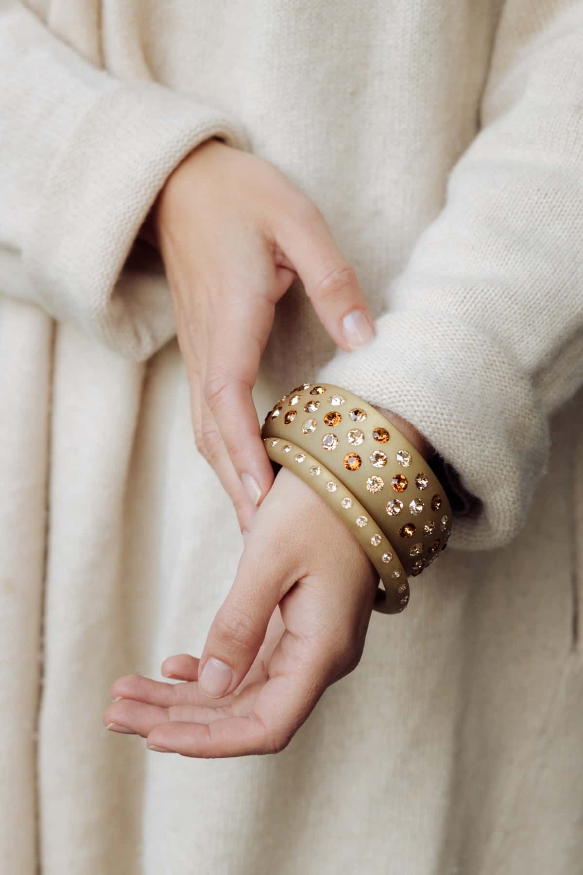 Hand mit Armreifen mit Kristallen in Beige. Hand with bangle with crystals in beige