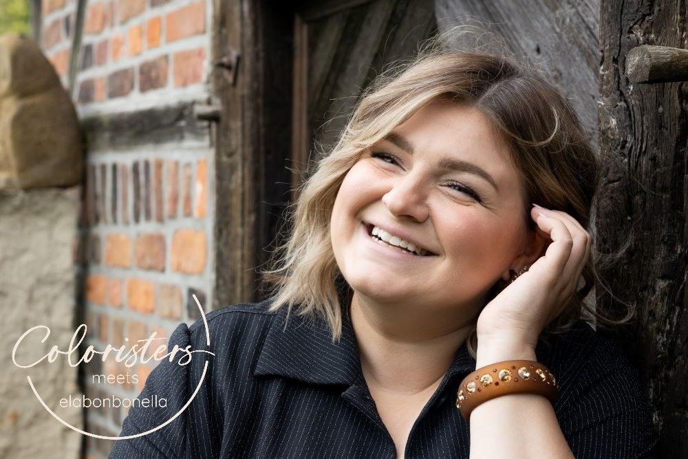 Lächelnde plus size Frau mit bunten Armreifen und Ohrringen mit Kristallen. Smiling plus size women with earrings and bangles with crystals.
