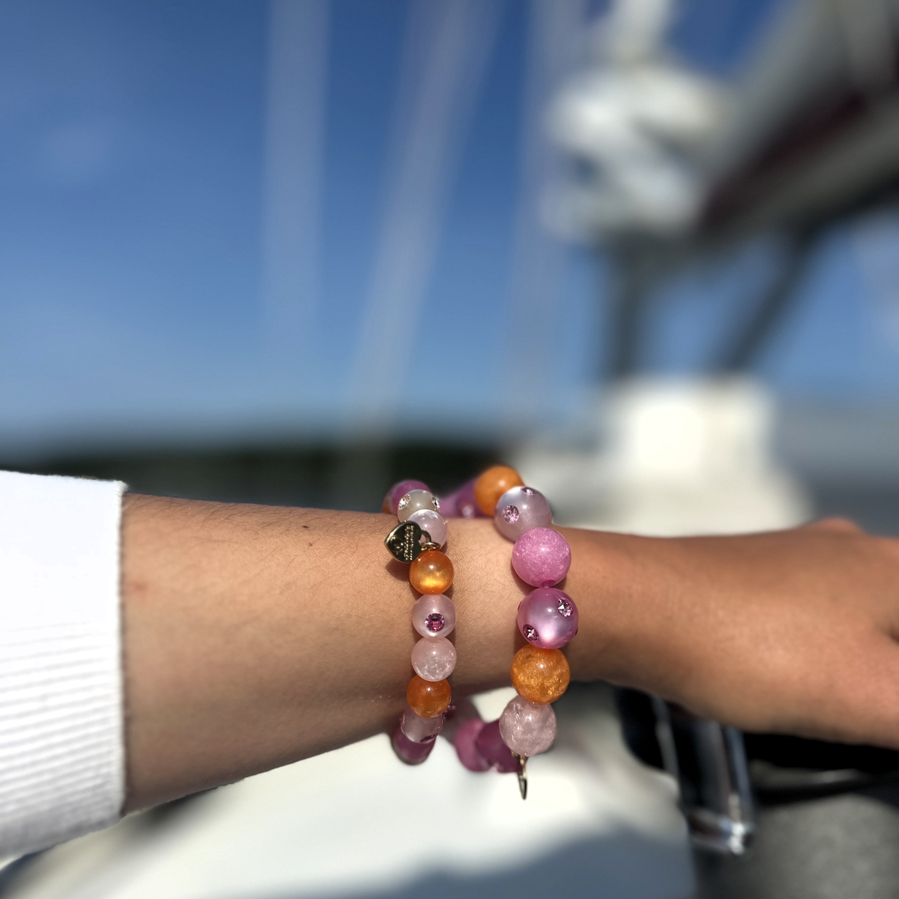 Hand mit bunten Coloristers Perlenarmbändern mit Kristallen. Hand with colourful Coloristers pearl bracelets with crystals.