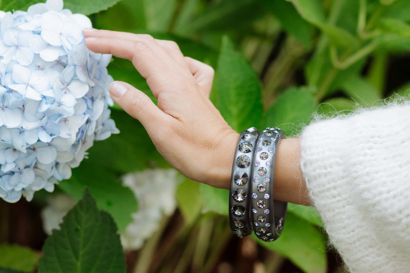 Hand mit grauen coloristers Armreifen mit Kristallen. Hand with grey coloristers bangles.