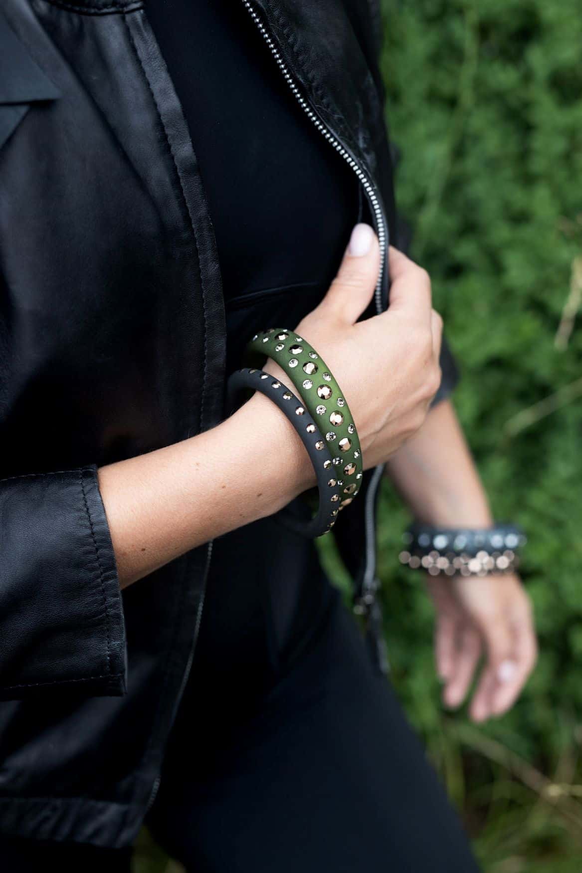 Hand mit Armreifen mit Kristallen in Khaki und gold. Hand with Bangle with crystals in khaki and gold.