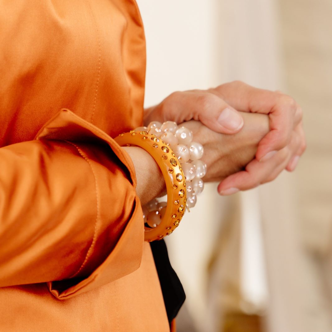Hand mit bunten Coloristers Armreifen mit Kristallen. Hand with colourful Coloristers bangles with crystals.