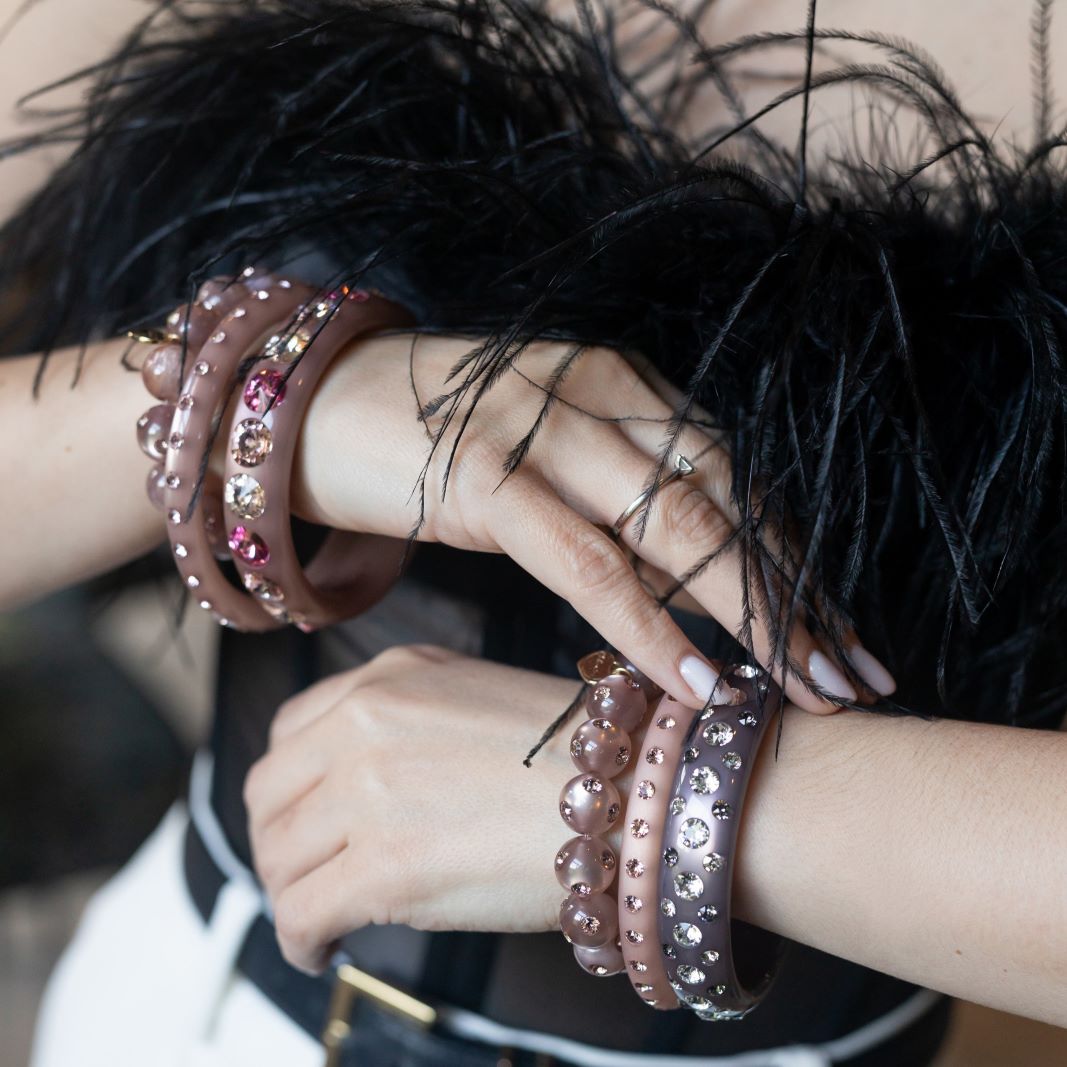 Hände mit glänzenden Coloristers Armreifen. Hands with sparkling Coloristers bracelets.Frau mit glänzenden Coloristers Armreifen. Women with sparkling Coloristers bracelets.