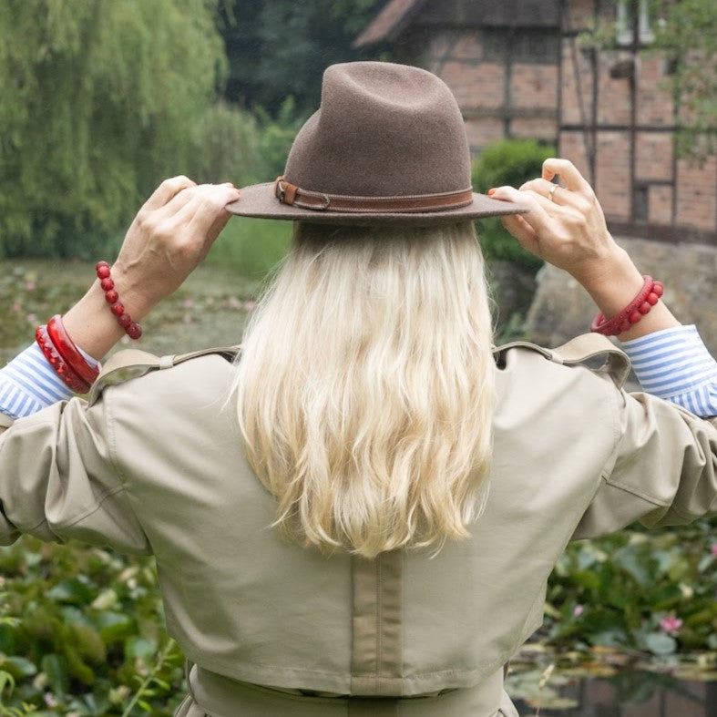 Hand mit roten Coloristers Armreifen mit Kristallen. Hand with ruby red Coloristers bangles with crystals.