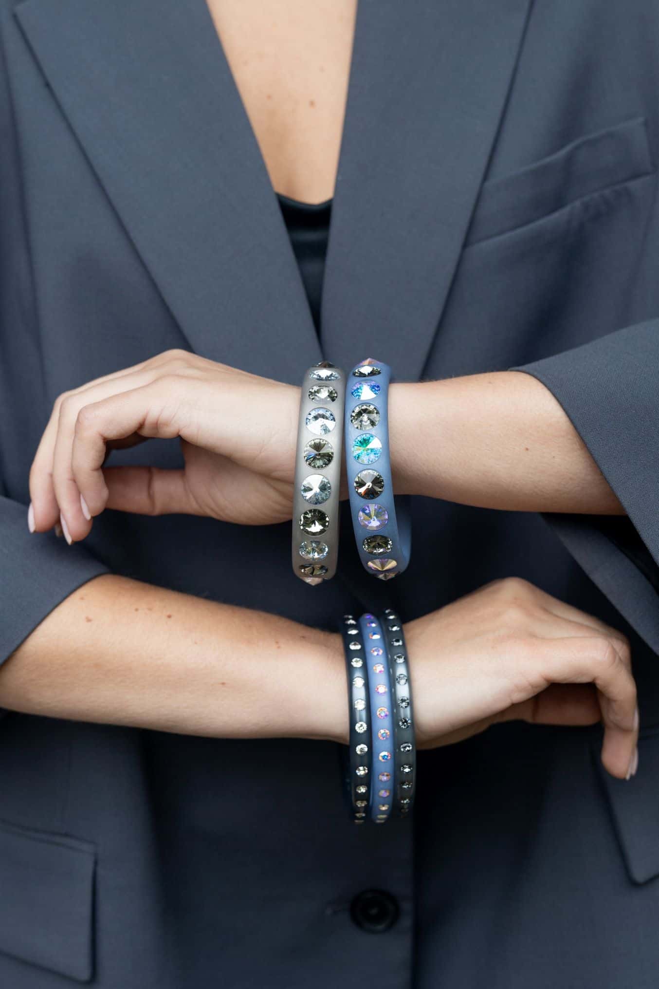 Arme mit grauen Coloristers Armreifen. Arms with grey Coloristers bangles with crystals.