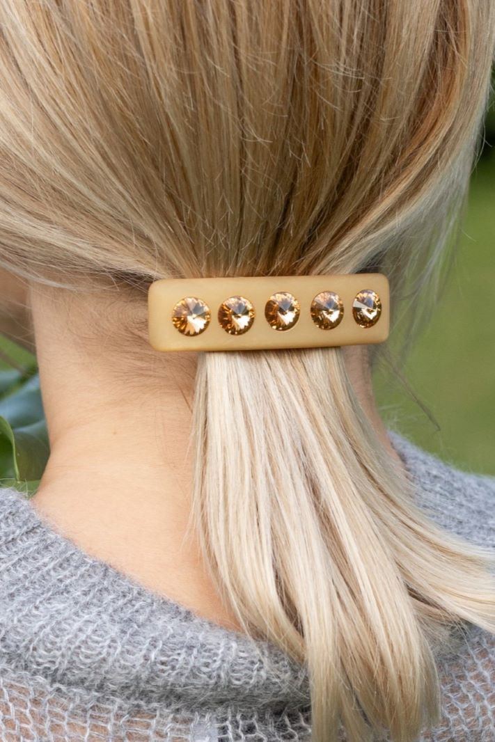 Frau mit Coloristers Haarspange Sassari in Beige. Woman with Coloristers Hair clip Sassari in beige.