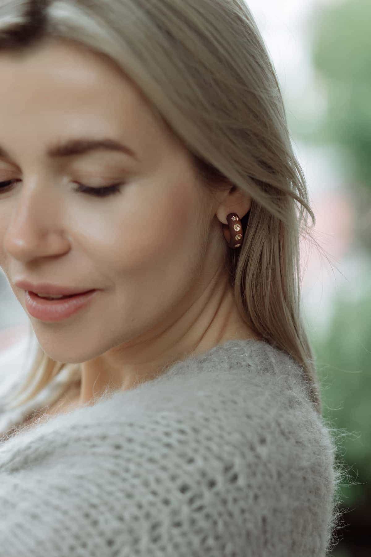Frau mit großen Ohrringen mit Kristallen in braun. Woman with large earrings with crystals in brown.