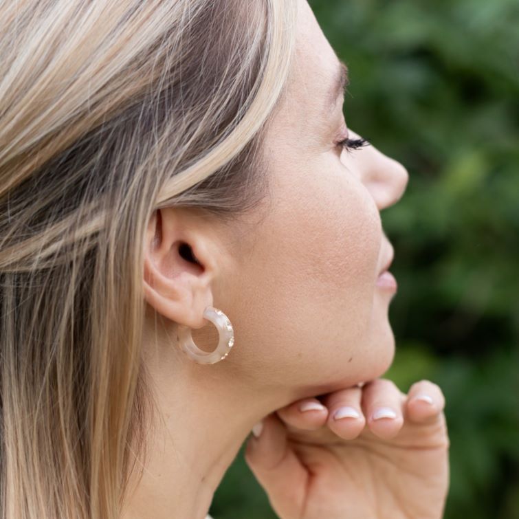 Frau mit Coloristers Ohrringen mit Kristallen. Women with Coloristers earrings with crystals.