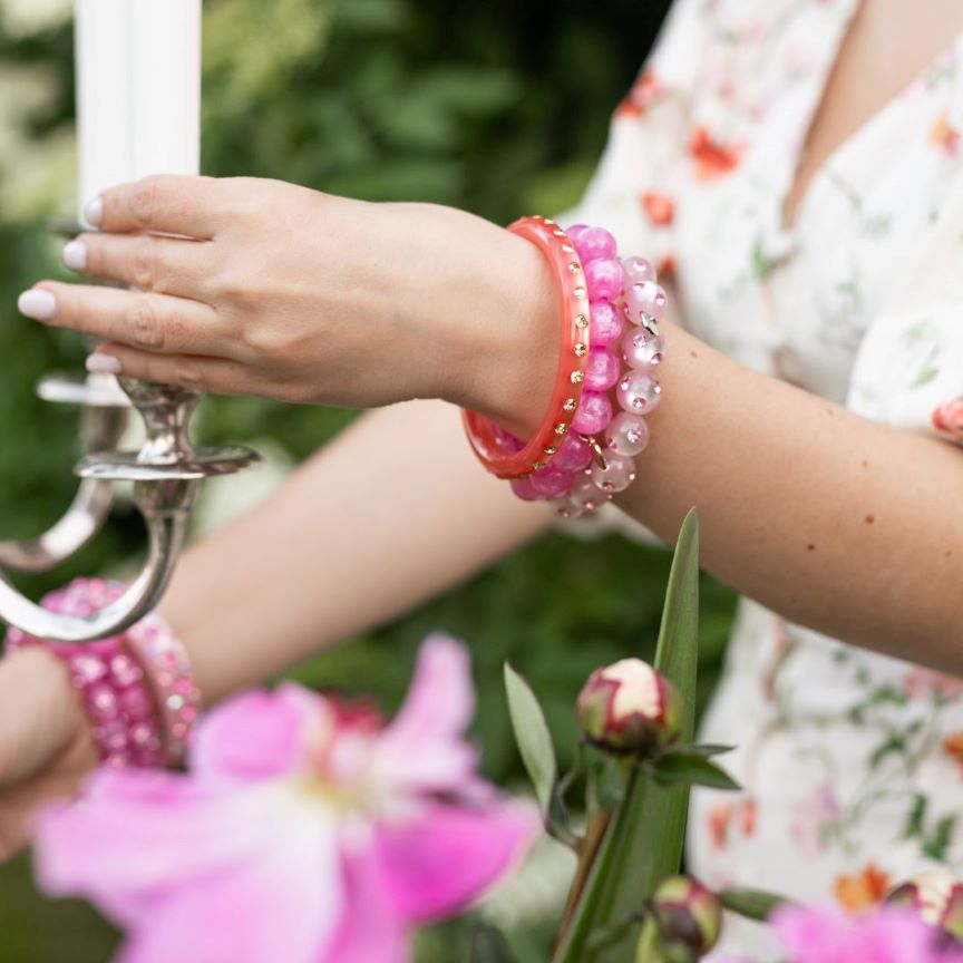 Hand mit bunten Coloristers Perlenarmbändern mit Kristallen. Hand with colourful Coloristers pearl bracelets with crystals.