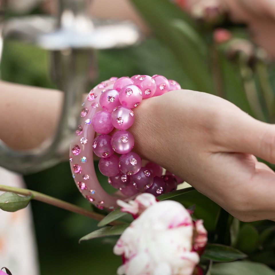 Hand mit bunten Coloristers Perlenarmbändern mit Kristallen. Hand with colourful Coloristers pearl bracelets with crystals.