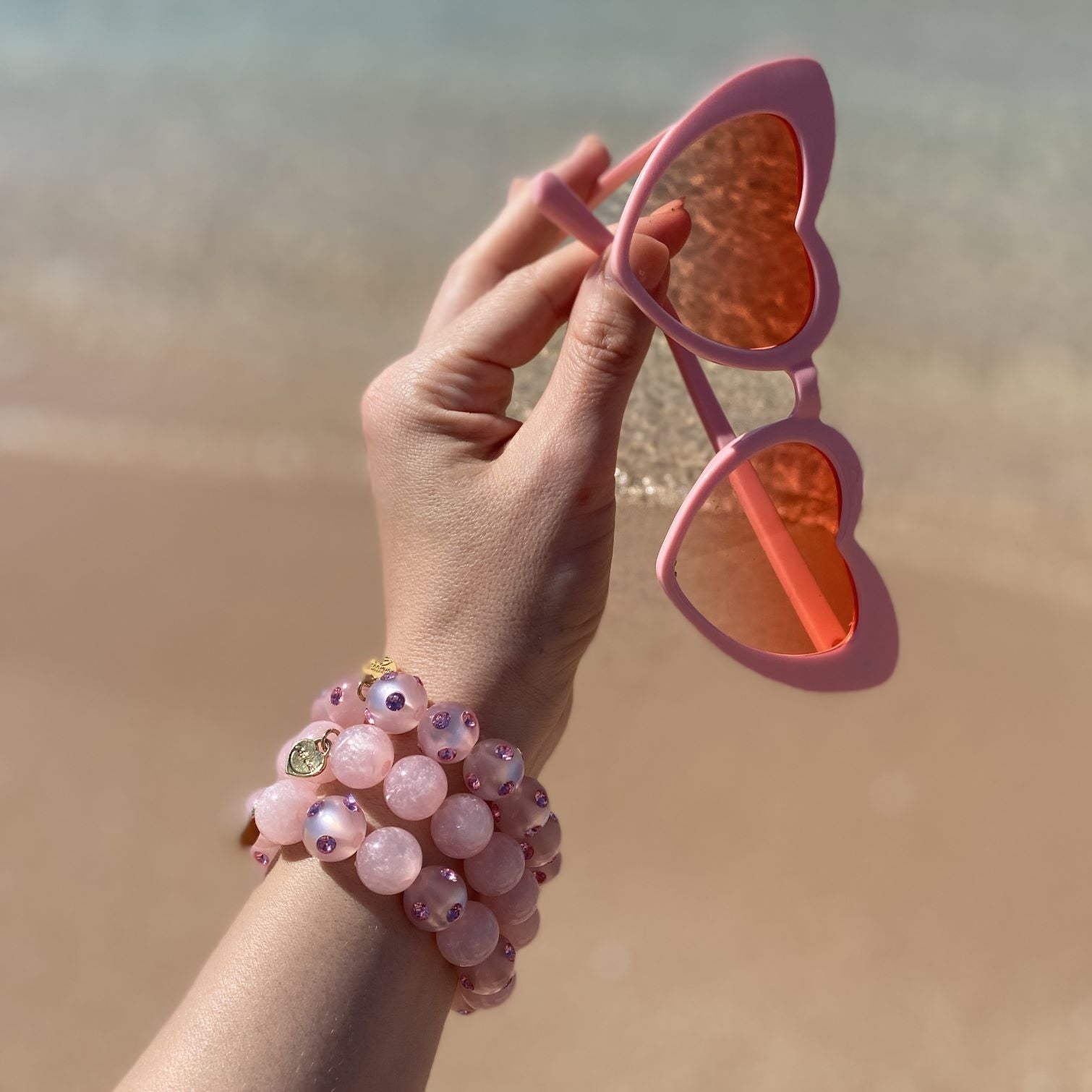 Hand mit bunten Coloristers Perlenarmbändern mit Kristallen. Hand with colourful Coloristers pearl bracelets with crystals.
