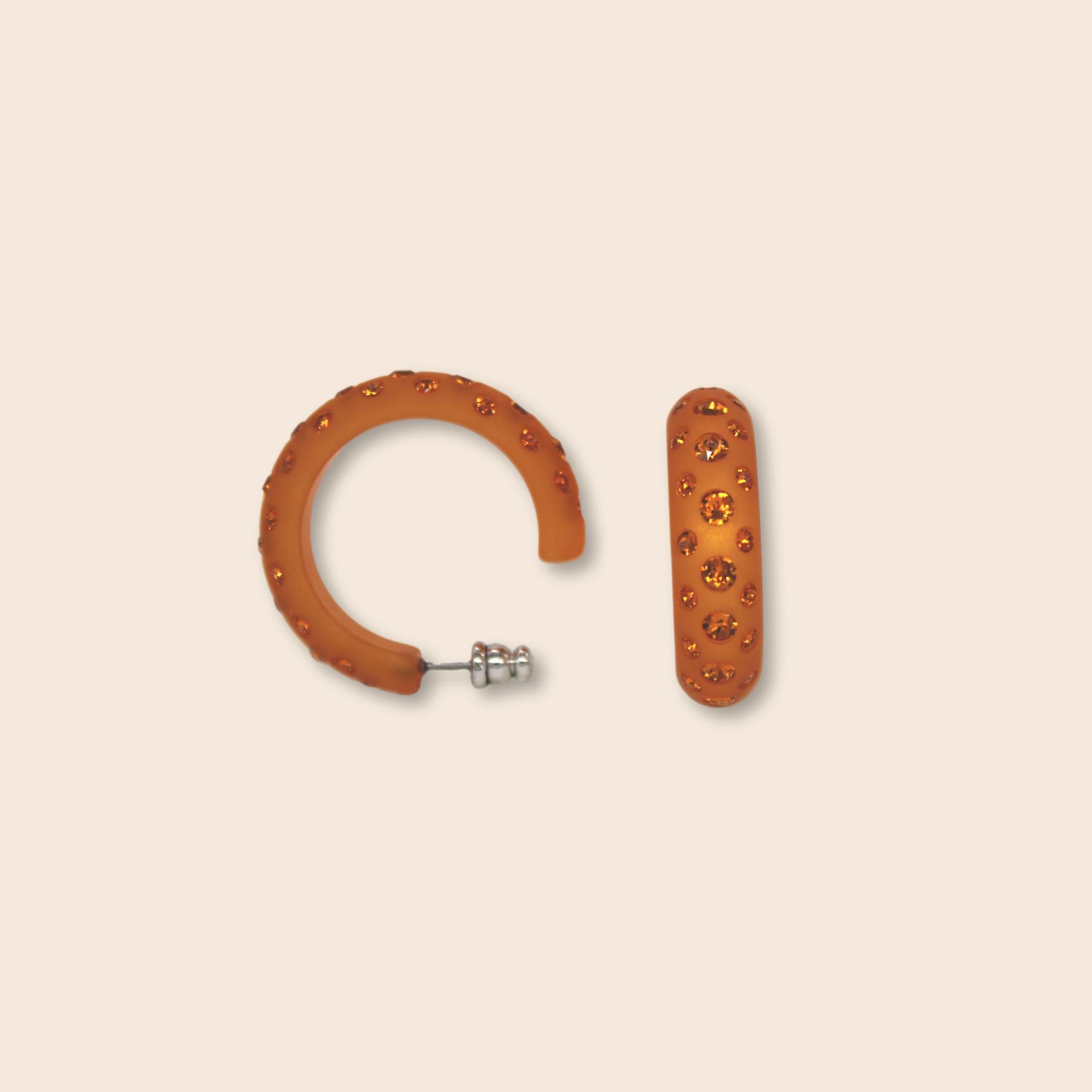 Die rund geschliffenen Catania Maxi-Creolen sind ein kunstvoll handgefertigtes Feuerwerk an Farbe und Glitzer. Sie veredeln jeden Auftritt und verbreiten Glamour und Lebensfreude. Orange steckt voller Energie, denn die Farbe verbindet die Wärme von Rot und das Strahlen von Gelb. Orange ist eine extravagante und extrovertierte Farbe, die sich sehr gut für besondere Akzente eignet.