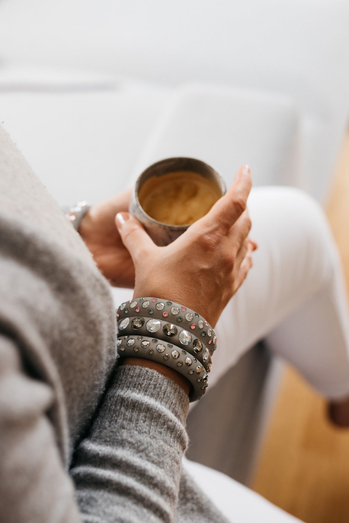 Hand mit grauen Coloristers Armreifen mit Kristallen. Hand with grey Coloristers bangles with crystals.