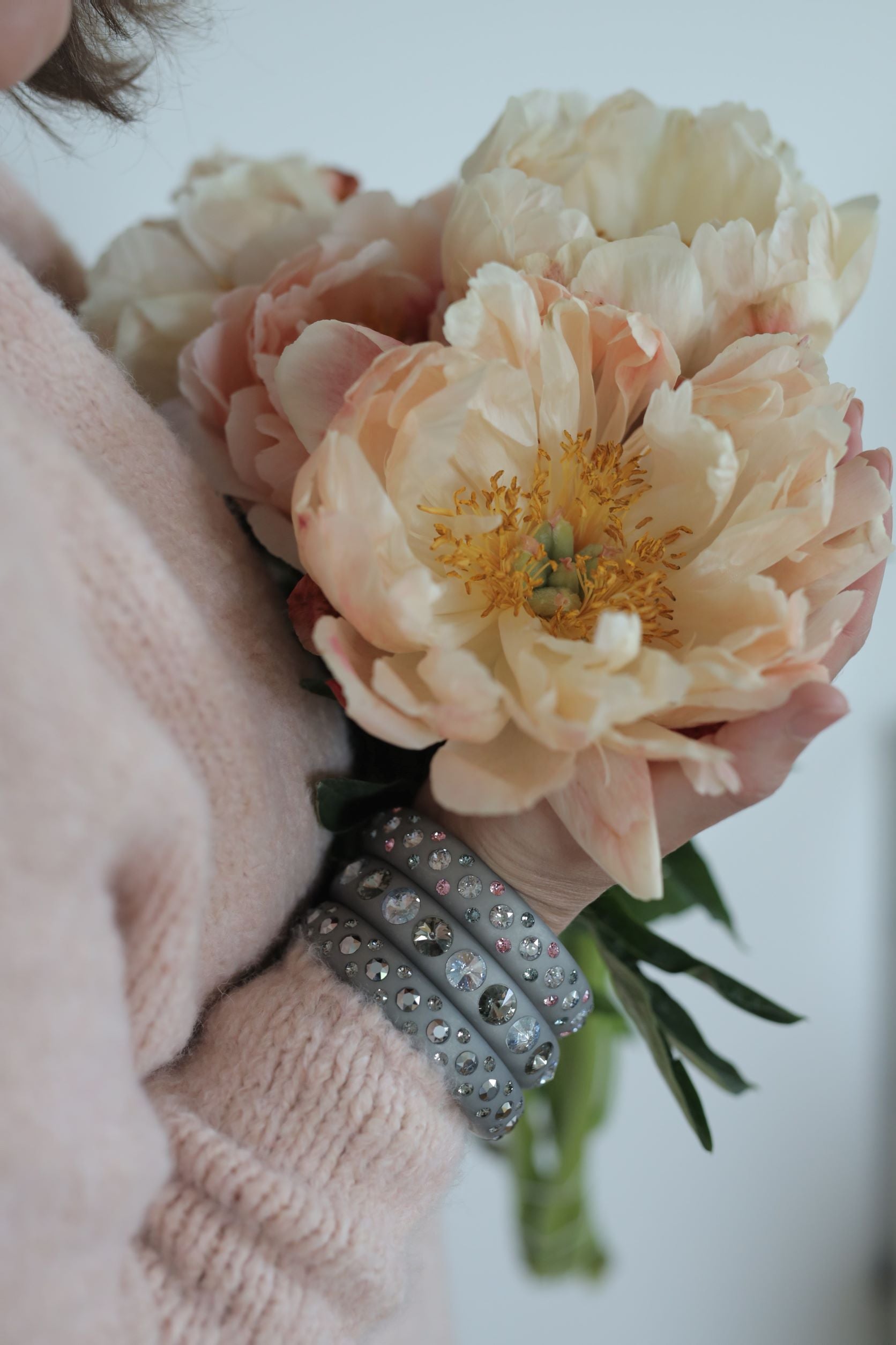 Hand mit grauen Coloristers Armreifen mit Kristallen. Hand with grey Coloristers bangles with crystals.