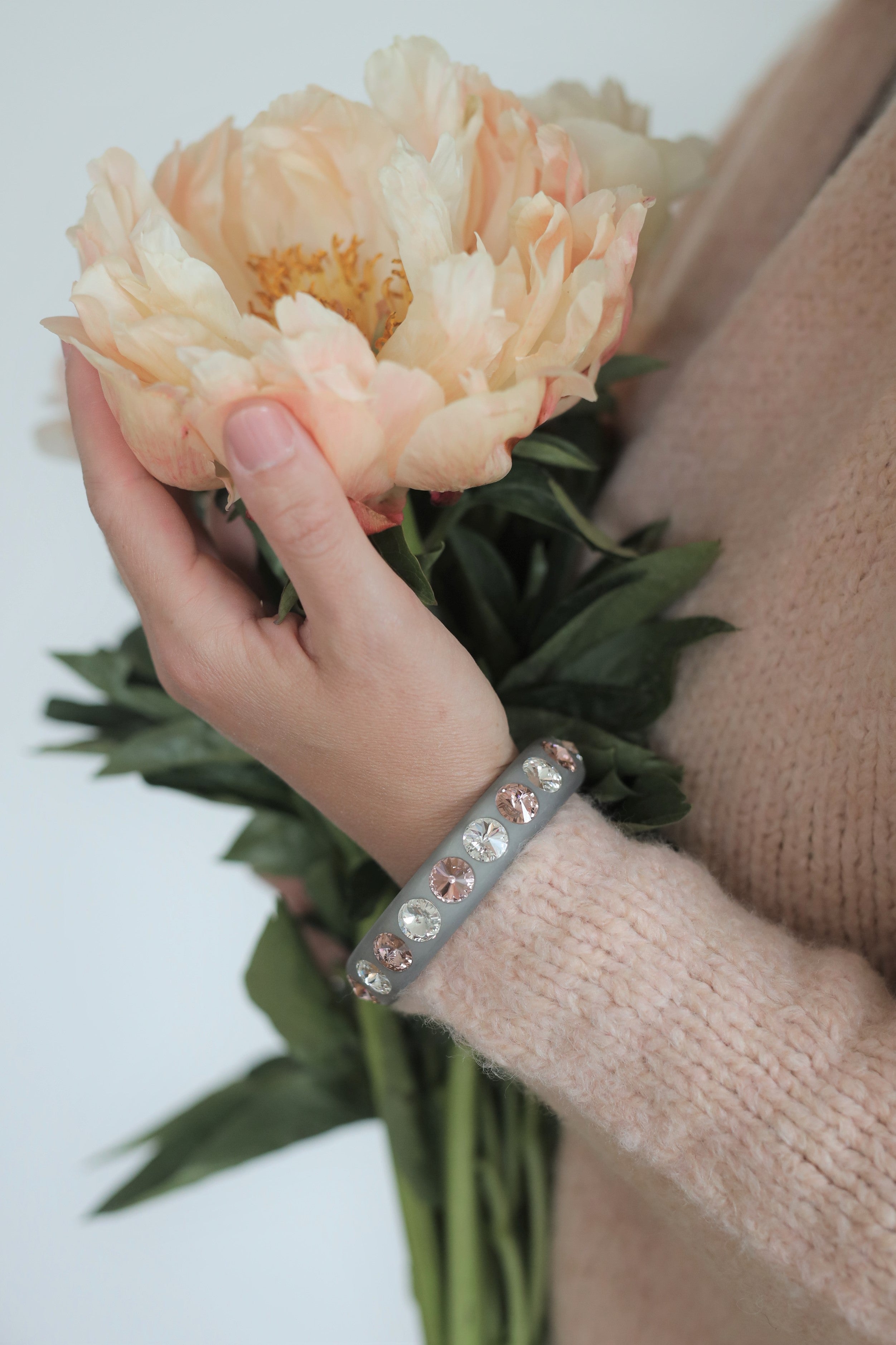 Hand mit grauen Coloristers Armreifen mit Kristallen. Hand with grey Coloristers bangles with crystals.