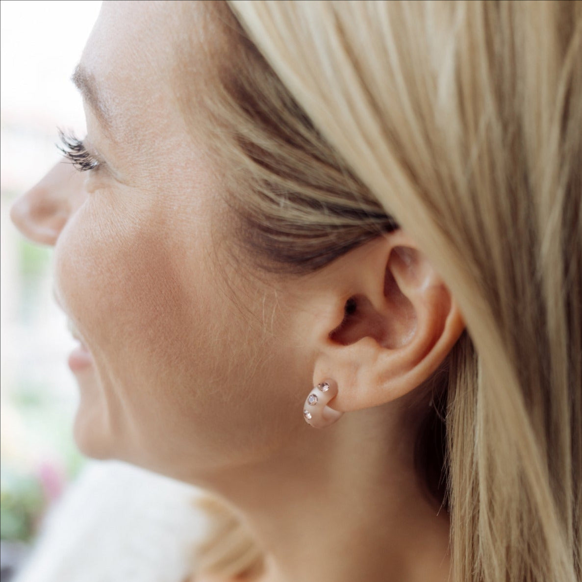 Frau mit Coloristers Ohrringen und Armreifen mit Kristallen. Women with Coloristers earrings and bangles with crystals.