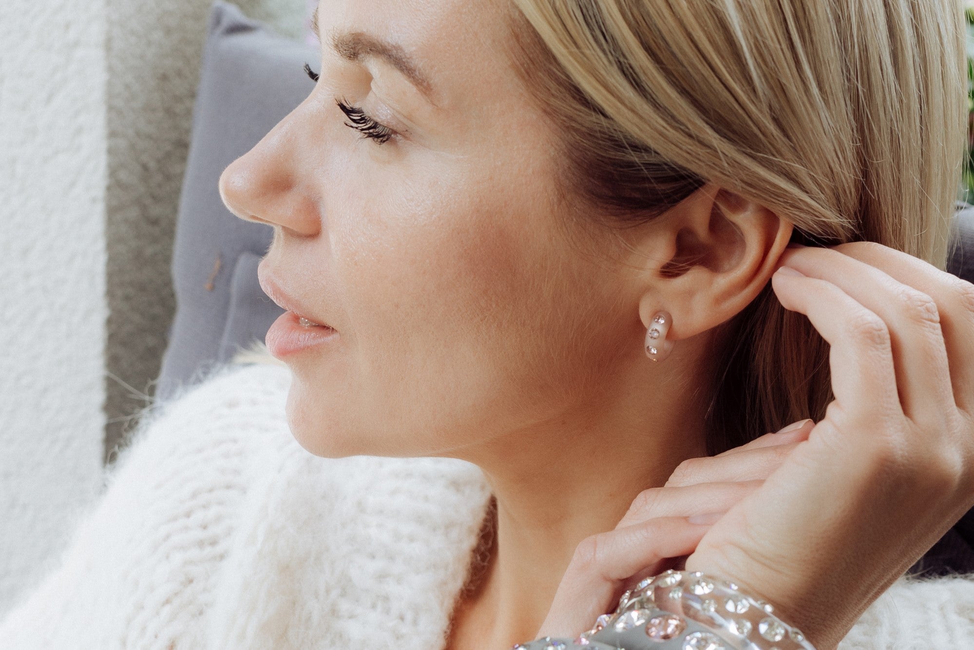 Frau mit Coloristers Ohrringen und Armreifen mit Kristallen. Women with Coloristers earrings and bangles with crystals.