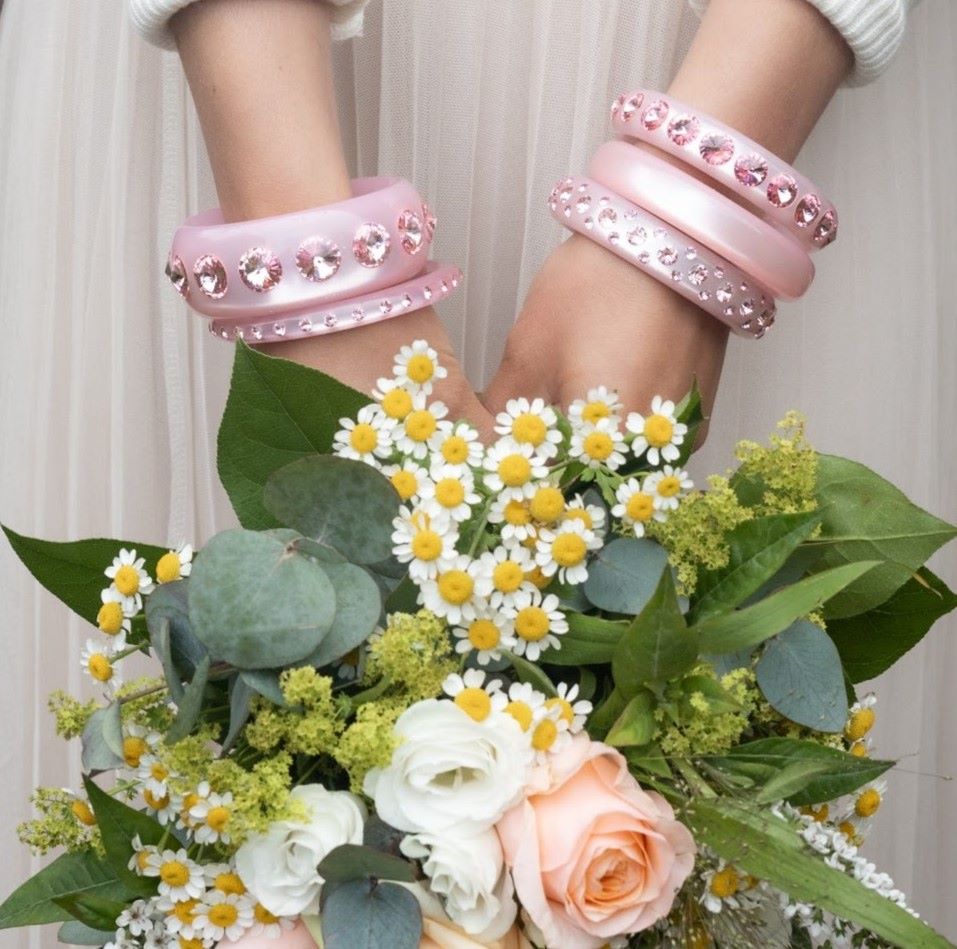 Hand mit rosa Coloristers Armreifen mit Kristallen. Hand with rosa Coloristers bangles with crystals. 