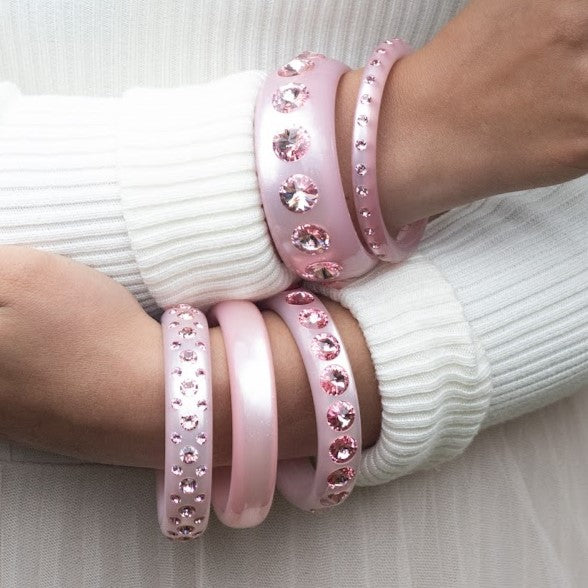 Hand mit rosa  Coloristers Armreifen mit Kristallen. Hand with rosa Coloristers bangles with crystals. 