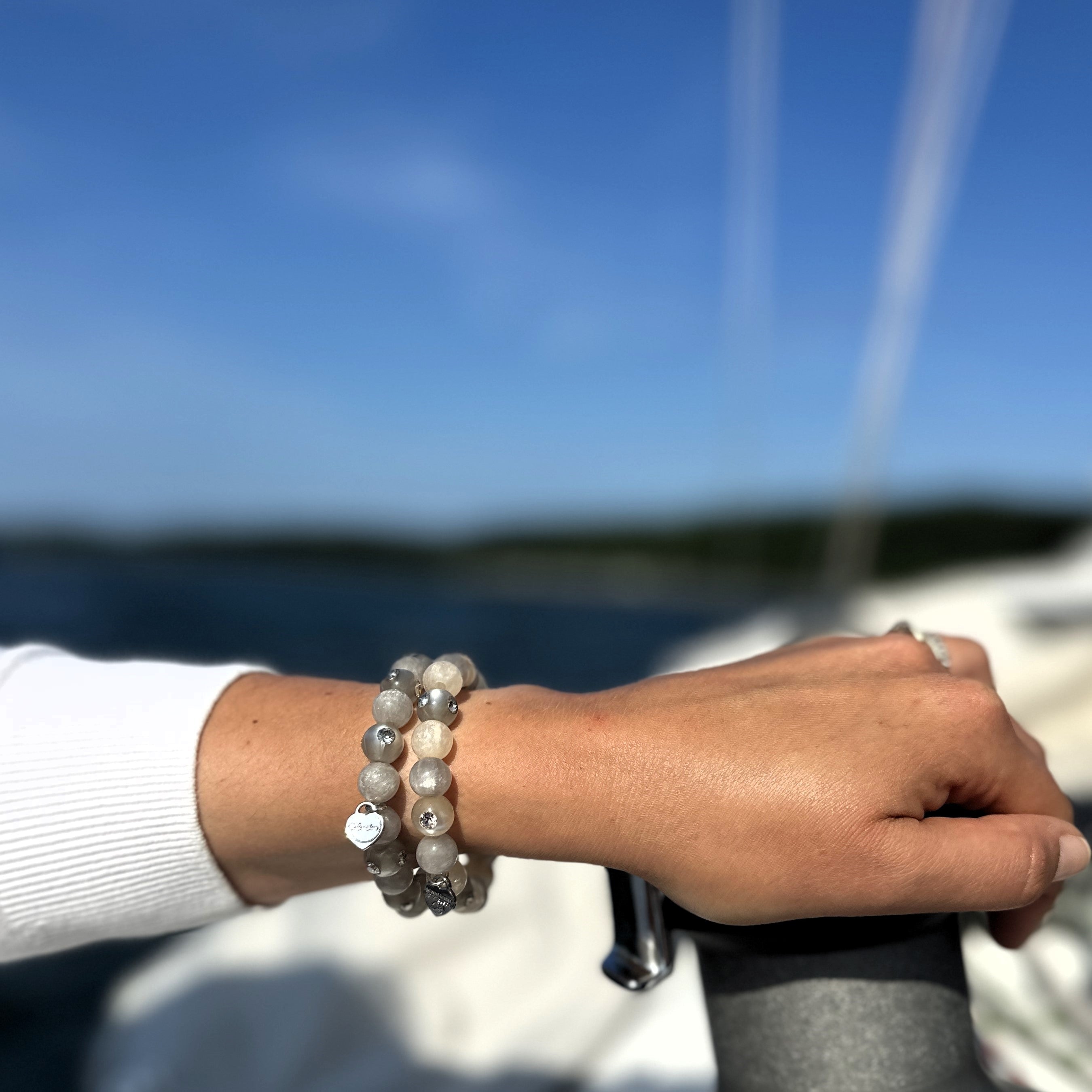 Hand mit bunten Coloristers Perlenarmbändern mit Kristallen. Hand with colourful Coloristers pearl bracelets with crystals. 